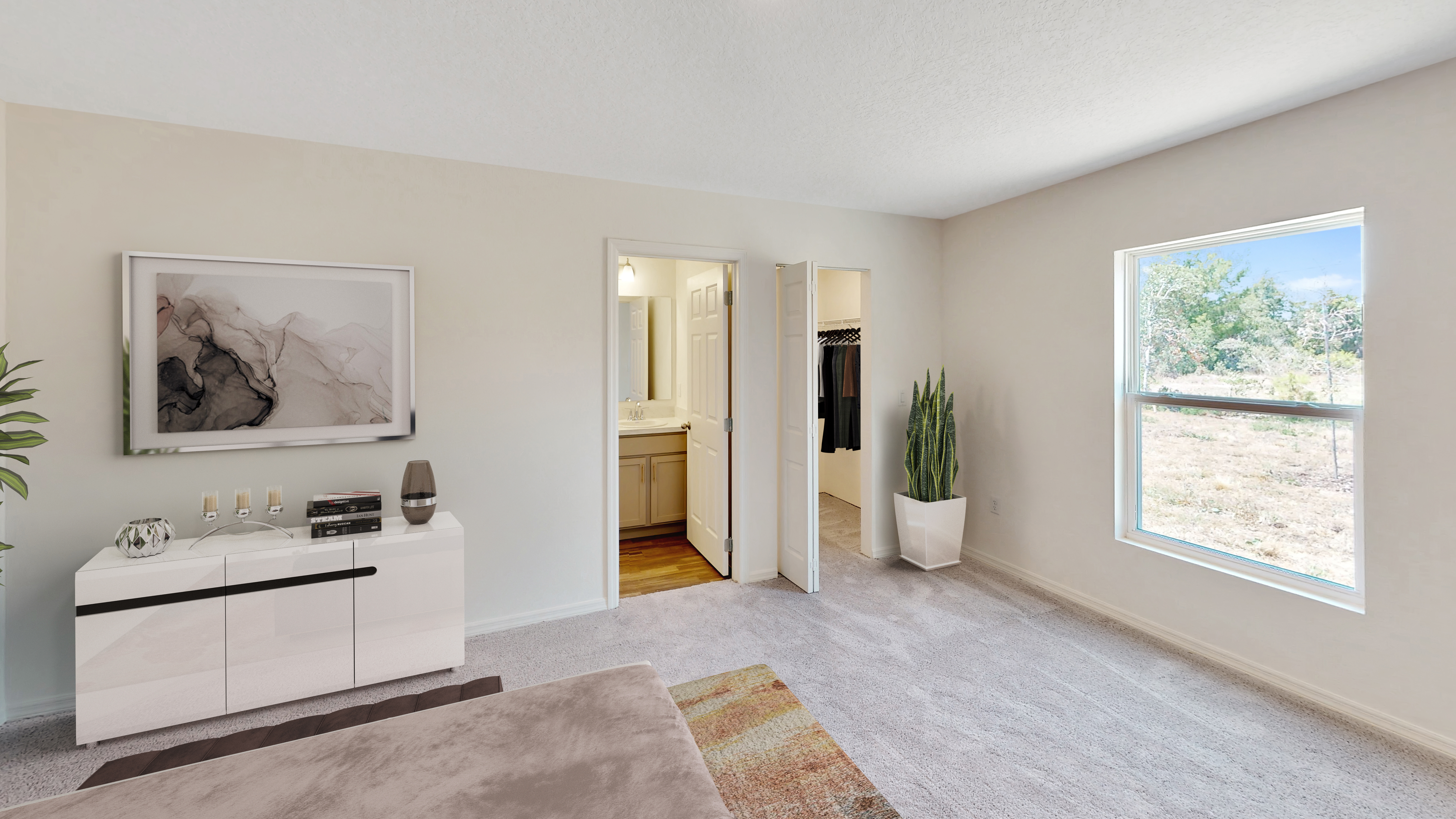 Spacious, modern bedroom with stylish decor, featuring a dresser, wall art, and an open view to a bathroom and walk-in closet.