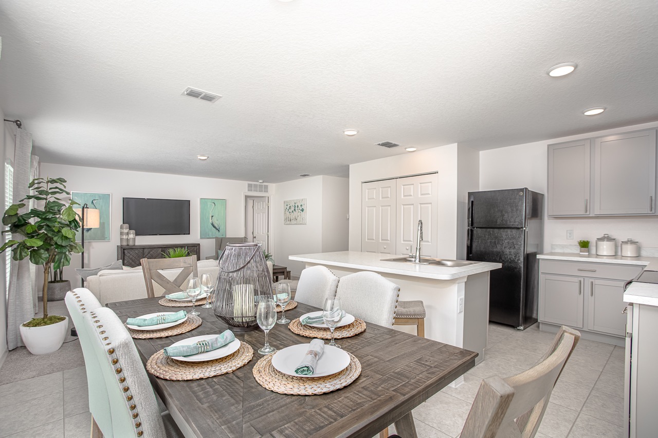 Modern open-concept kitchen and dining area with elegant table setting and contemporary decor.