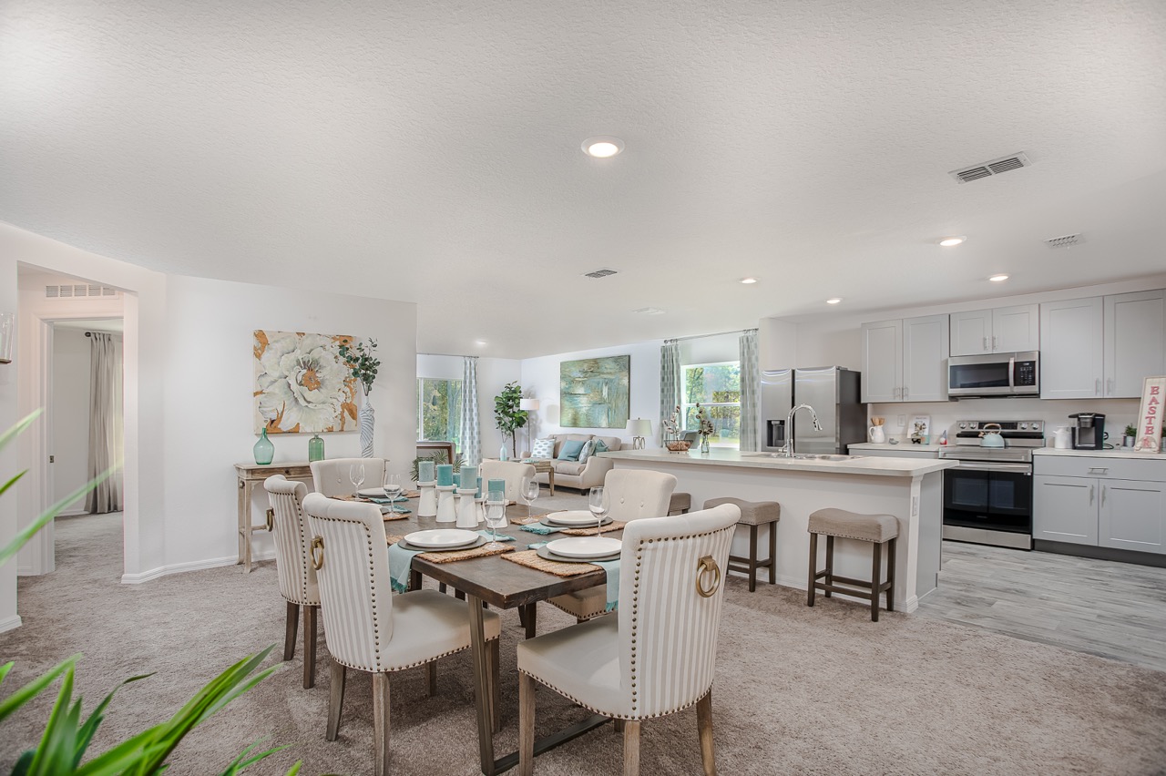 Modern open-concept living and dining area with neutral tones and elegant furnishings in a bright home interior.