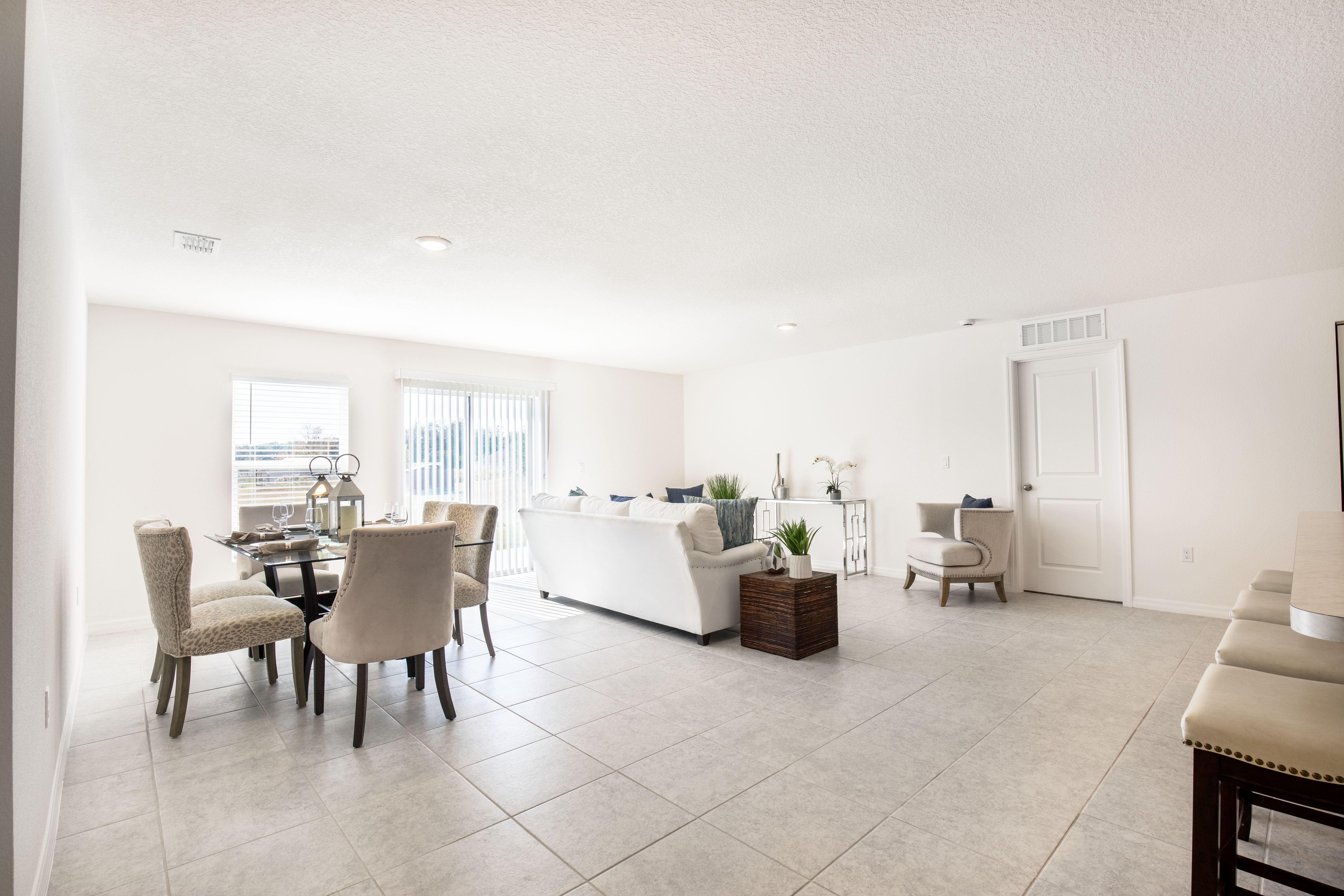 Bright and spacious open floor plan living and dining room with modern furniture and large windows.