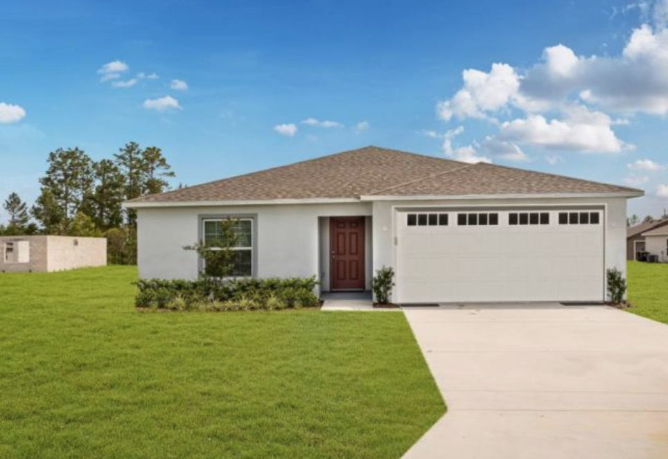 Single-story modern home with a two-car garage, lush green lawn, and a clear blue sky backdrop.
