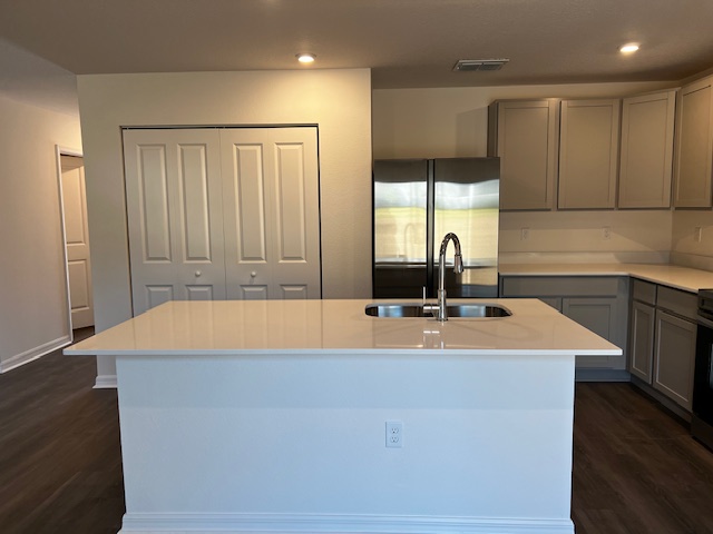 Modern kitchen interior with a large island, stainless steel appliances, and sleek cabinetry.