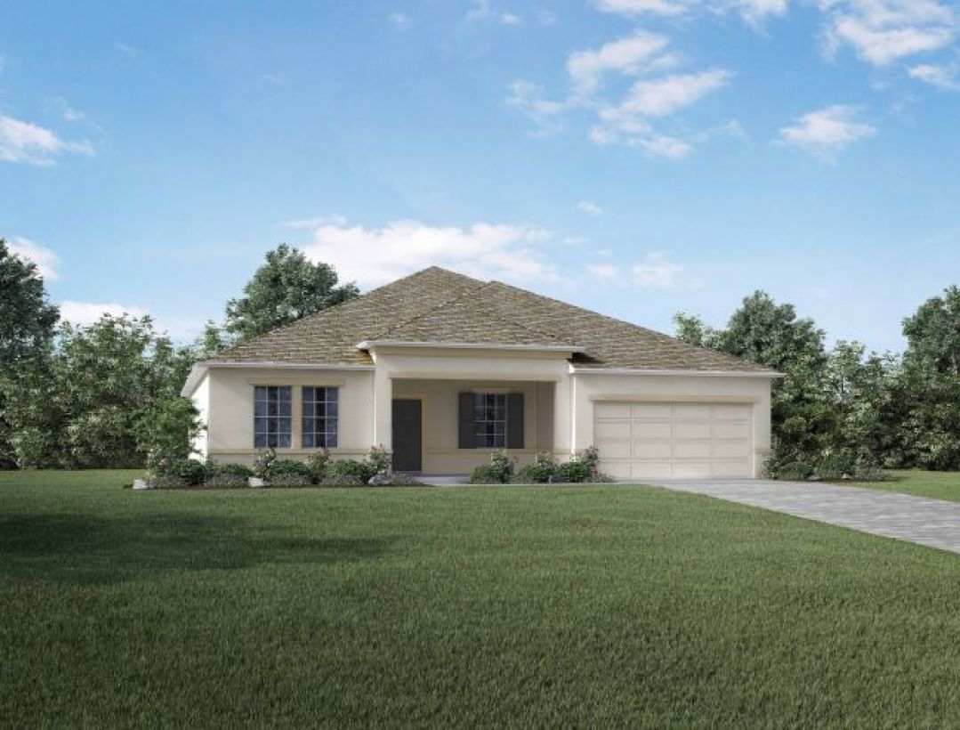 Single-story suburban home with a well-maintained lawn, surrounded by trees, under a clear blue sky.